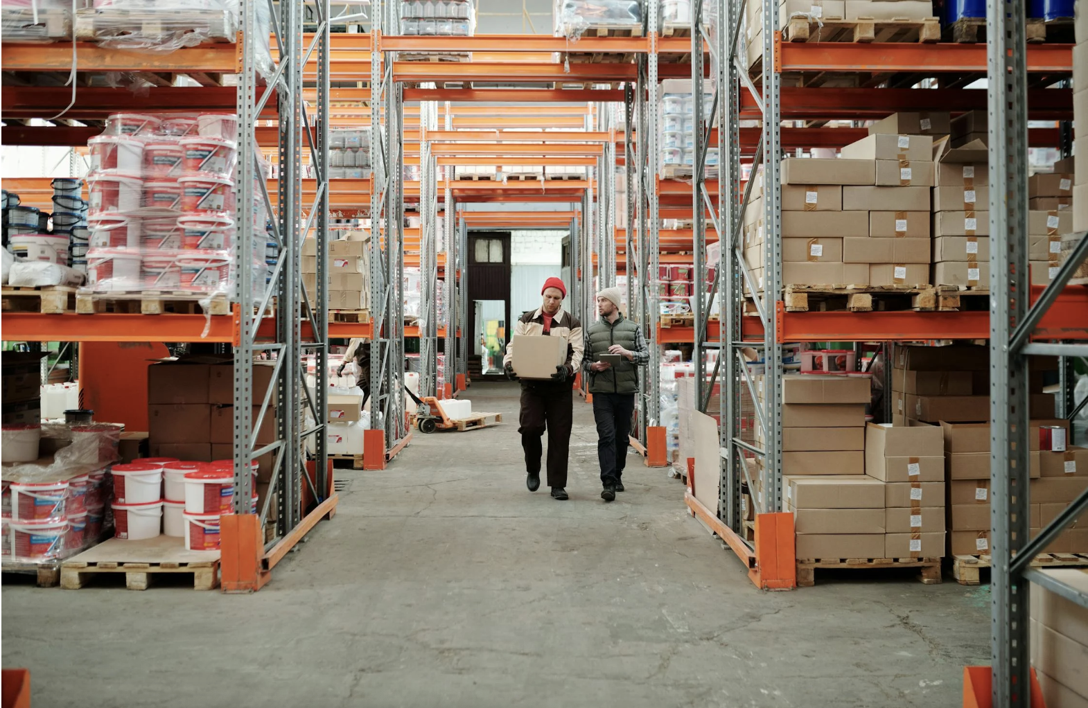 two people walking down a large warehouse
